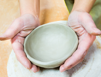 hands molding clay pot