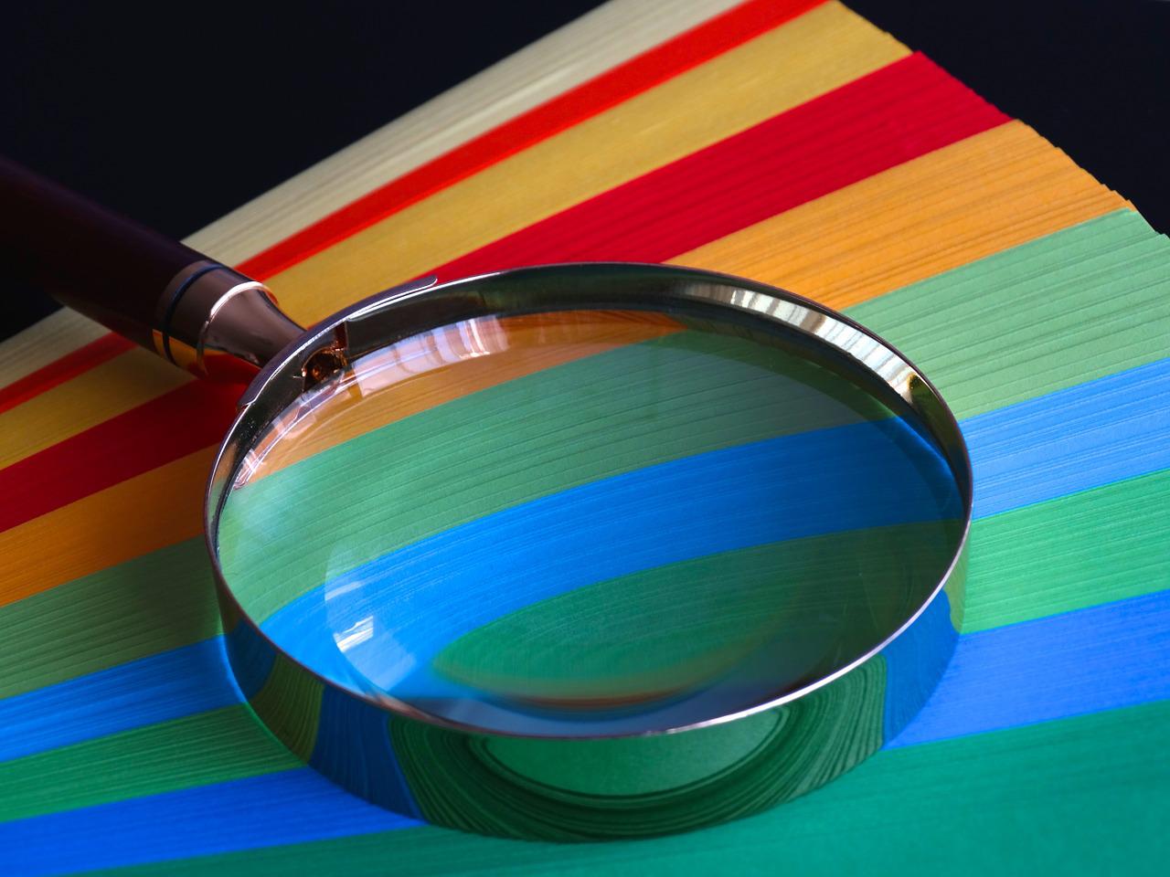 magnifying glass on top of colorful paper