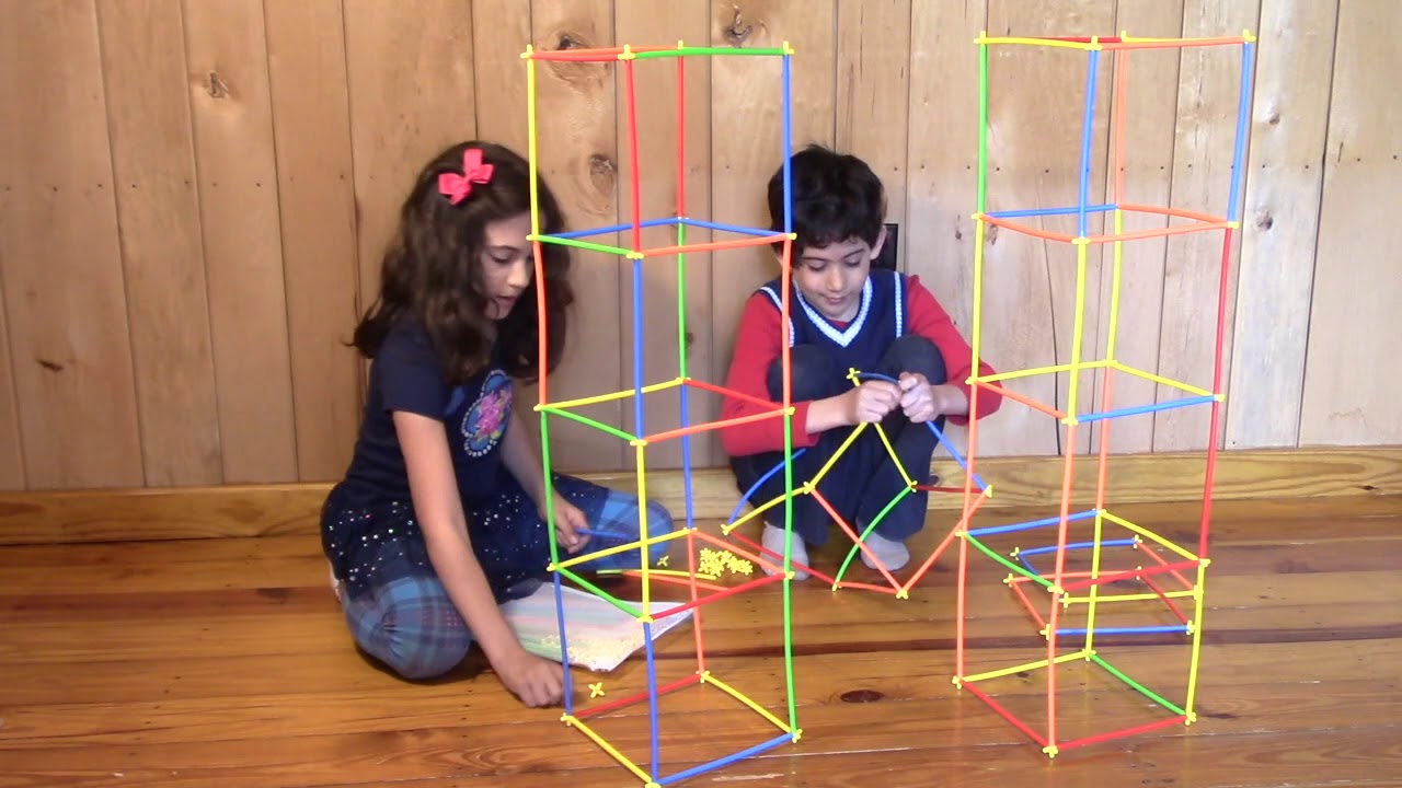 girl and boy building with straws