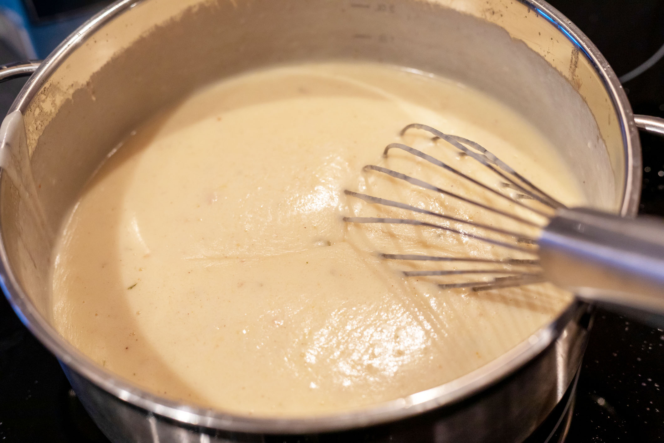 bechamel sauce in pan with whisk