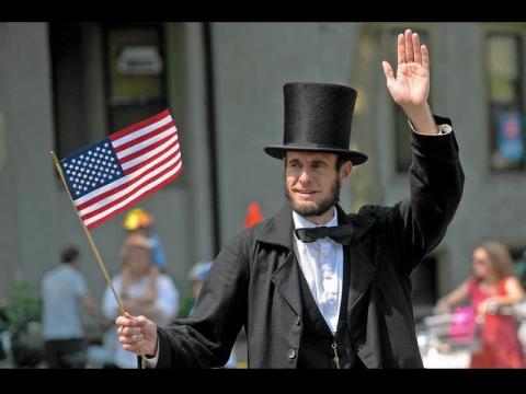 Abe Lincoln performer with flag in a parade