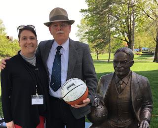 James Naismith re-enactor holding basketball next to Naismith statue