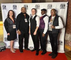 band standing together on a red carpet at an event