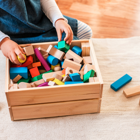 kid removing blocks from toybox