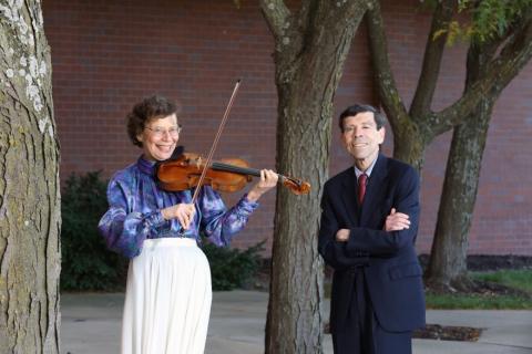 Photo of the musicians - Susan playing her violin standing next to William