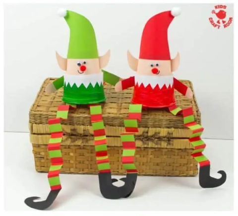 paper elves sitting on basket against white background