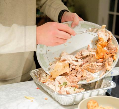 man scraping leftovers into a container