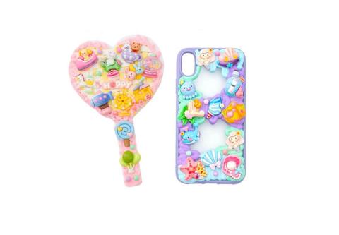 hand mirror and phone case decorated with brightly colored charms and bling