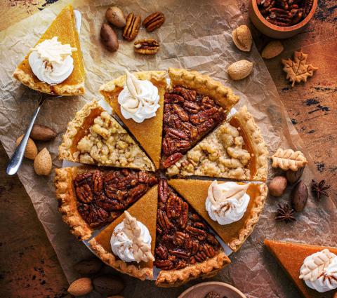 pie plate with alternating pieces of pumpkin, pecan and Dutch apple pie, with dollops of whipped cream on the pumpkin pieces