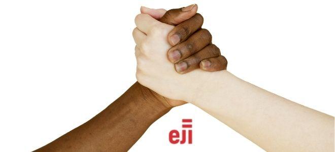 one black and one white hand clasped together