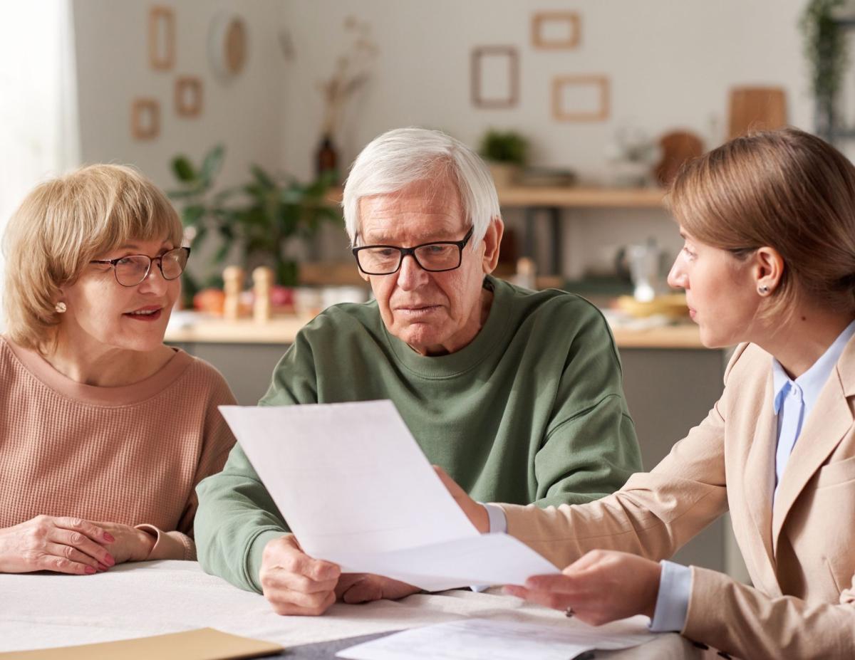 older couple looking at paperwork with younger woman