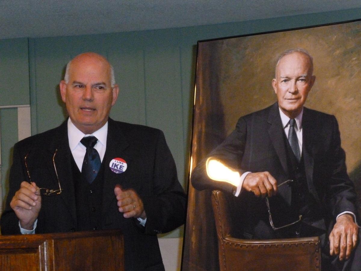 Historical performer next to portrait of Eisenhower