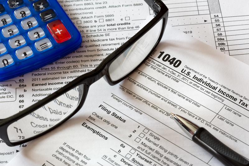 calculator, glasses and tax forms