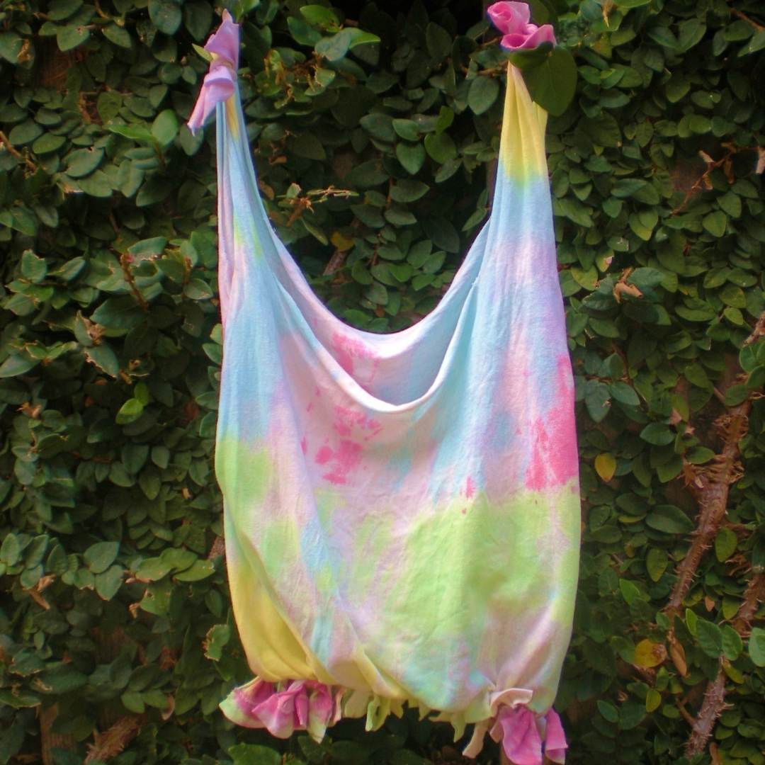 pastel tie tie dye tote bag against leafy background