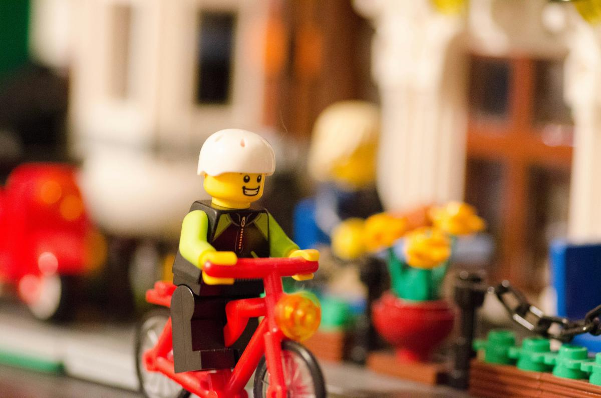 a lego man riding a bike through a lego city