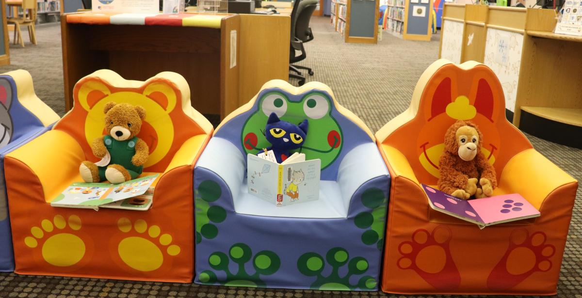 stuffed animals reading books in the library