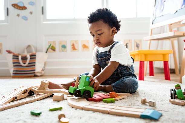 toddler playing with wooden blocks inside 